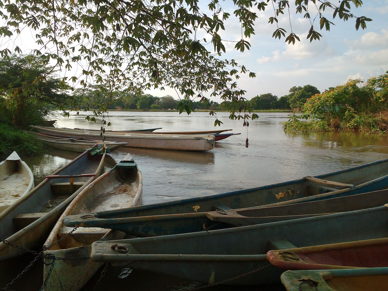 Canoes resting on the calm water of a wide canal.